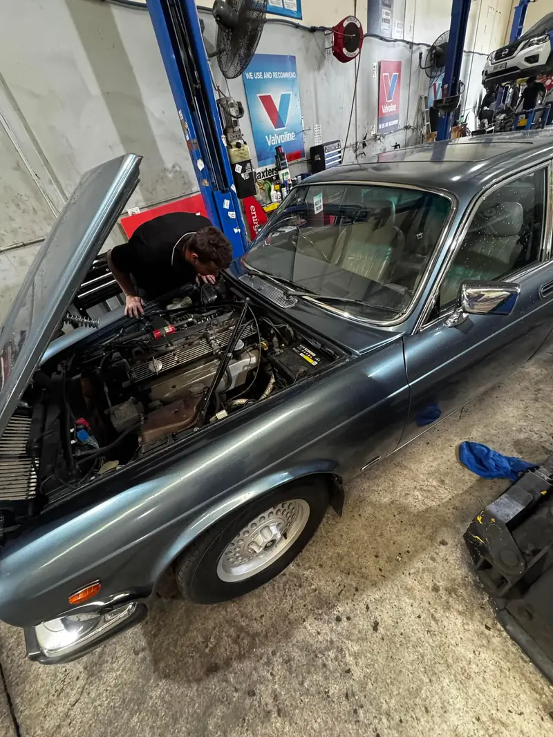 Car with bonnet up in the workshop for diagnostics