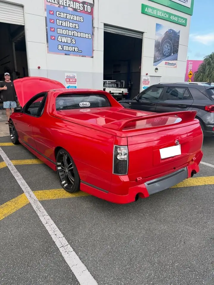 Red ute with rear wing parked outside the workshop
