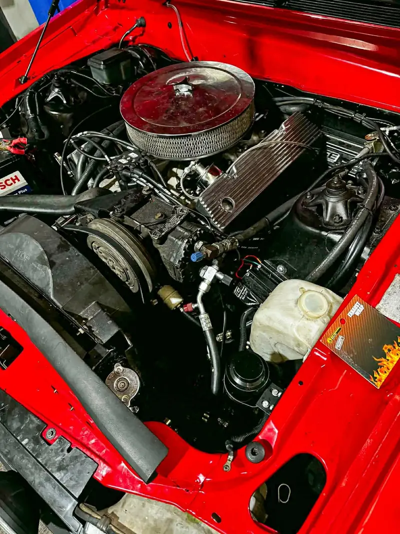 V8 engine bay of a red performance car in the workshop