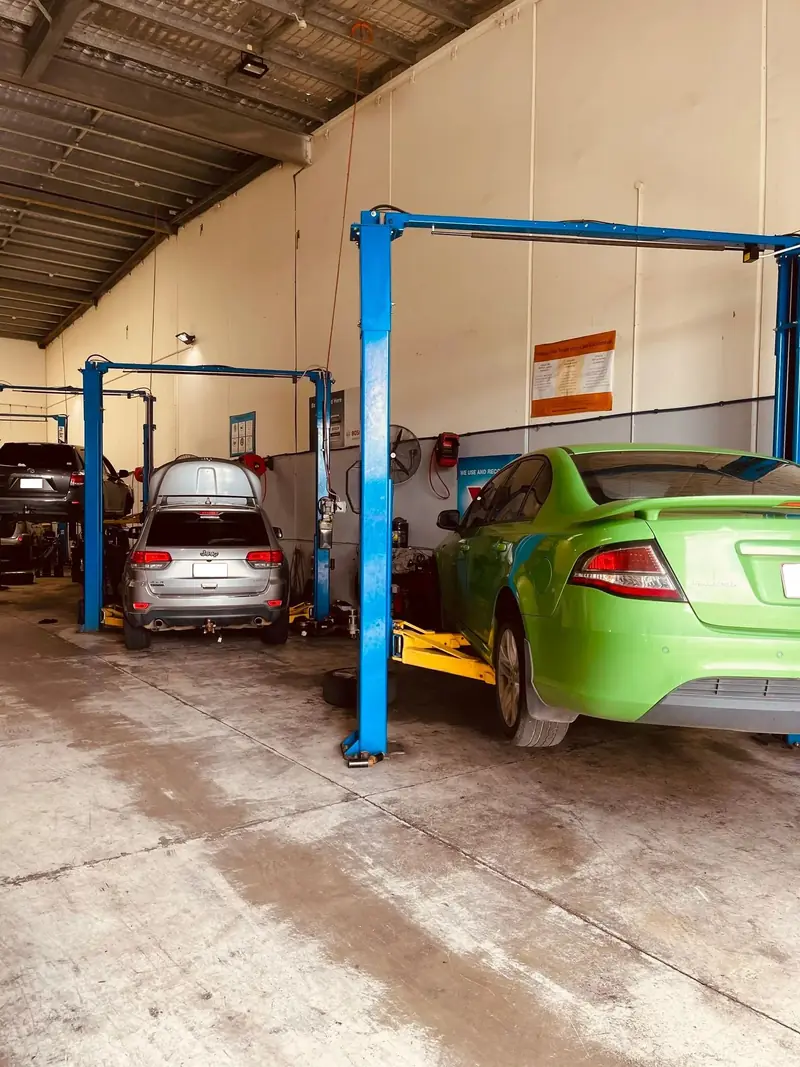 Cars in the service bays and on hoists inside the Elite Fleet Auto workshop in Cannonvale
